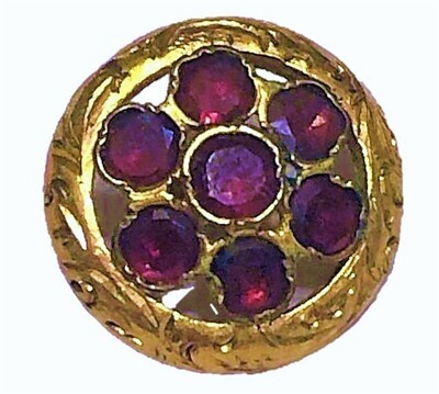 A SMALL SOLID GOLD BUTTON WITH GARNETS
