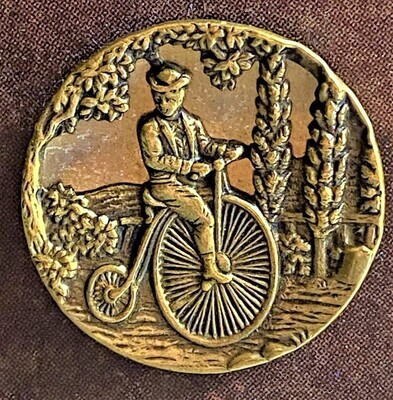 A SCARCE LARGE MIRRORED BACK FIGURE ON A HIGH WHEEELER BICYCLE