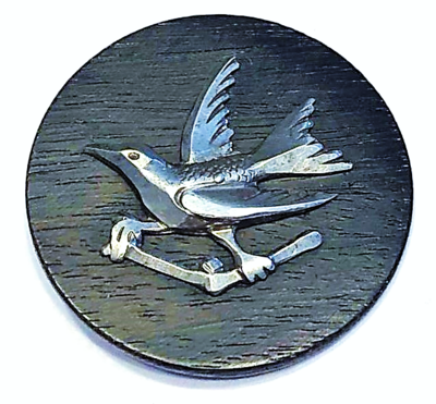 A LARGE WOOD BUTTON WITH STEEL BIRD