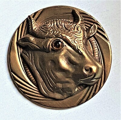 A LARGE MEDIUM HIGH RELIEF COW WITH GLASS EYE