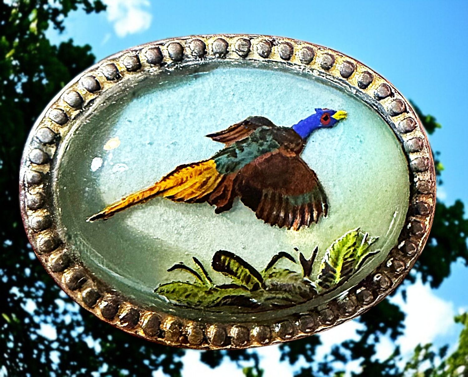 A Sterling silver mounted revrse painted glass flying bird.