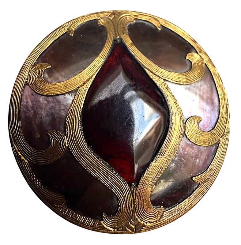 A large pearl and glass in metal button from the 19th century.