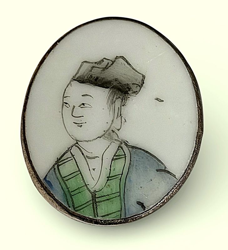 A LARGE OVAL CHINESE GLASS IN METAL BUTTON