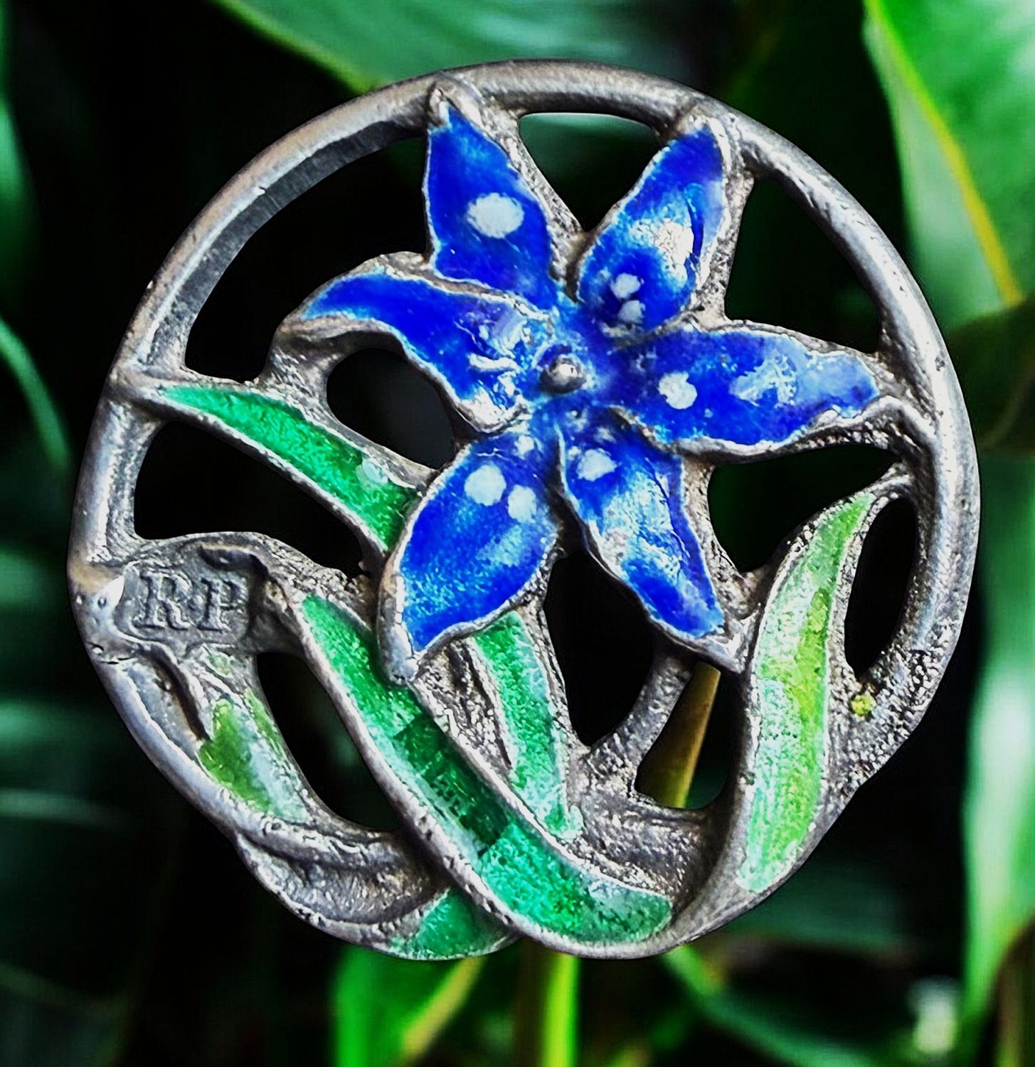 A beautiful Art Nouveau pierced silver and enamel floral button.