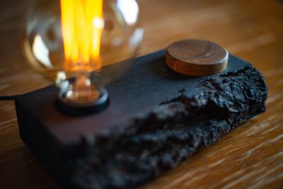Loft-style table lamp with a natural wood base featuring rough bark texture and a round wooden knob, with an Edison lamp