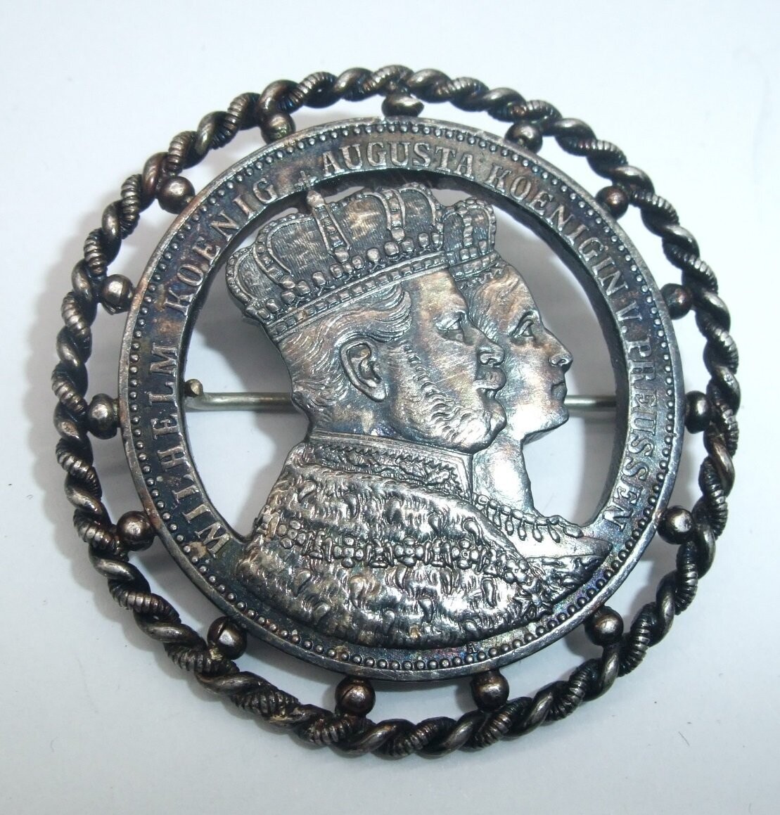 Preussen: Brosche aus Krönungsthaler 1861 Wilhelm und Augusta Königin von Preussen, in Silberrahmen gefasst.