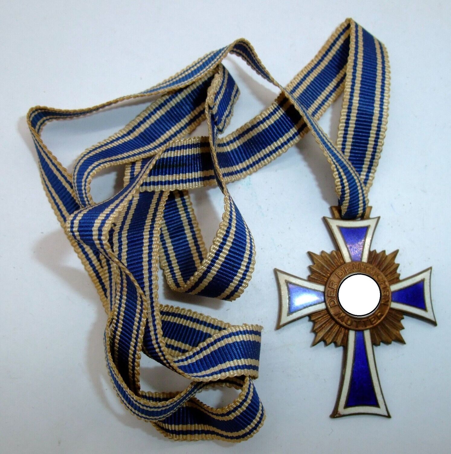 Mutterkreuz in Bronze, 3. Stufe, am konfektionierten Band, Emaille vollständig erhalten.