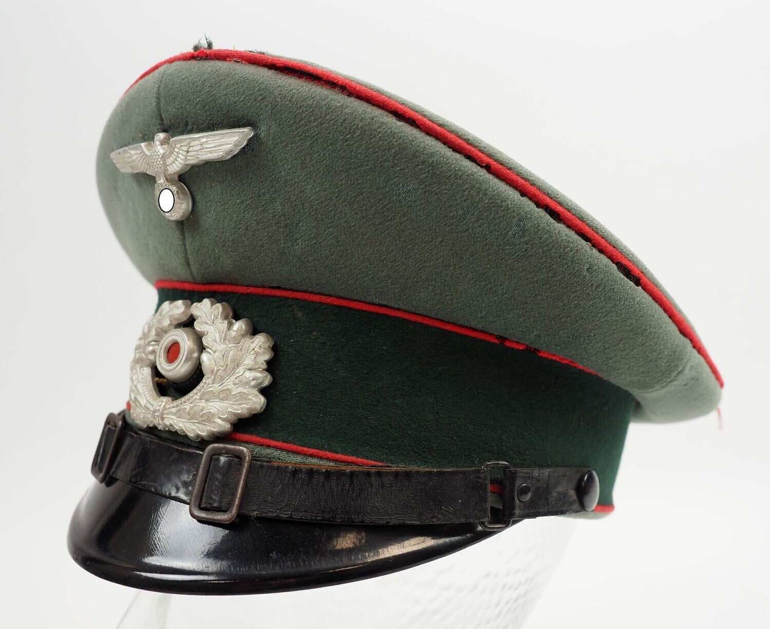 Wehrmacht: Schirmmütze für Unteroffiziere und Mannschaften der Artillerie, Cellon-Trapez "Die Qualitätsmütze", Mottenschäden.