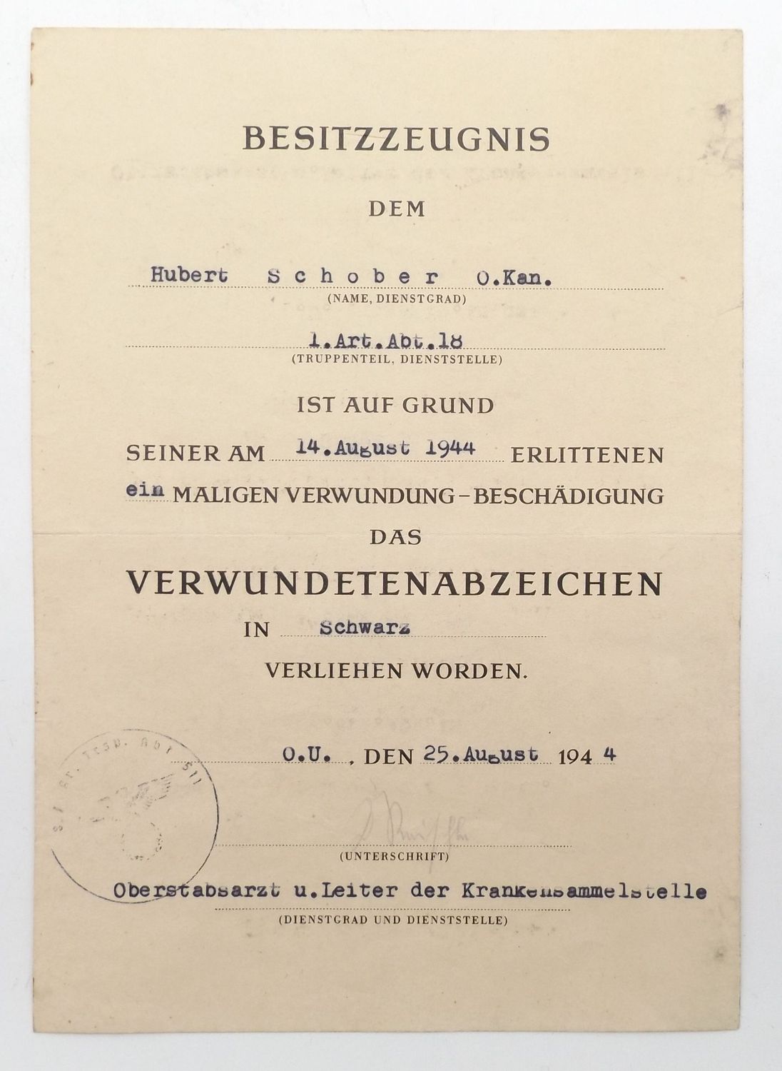 Wehrmacht: Besitzzeugnis zum Verwundetenabzeichen in Schwarz für einen Oberkanonier in der Artillerie-Abteilung 18, 25. 8. 1944, OU.