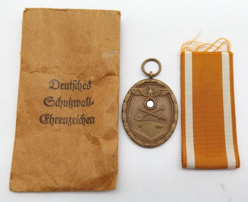 Deutsches Schutzwall Ehrenzeichen, Für Arbeit zum Schutze Deutschlands, Hersteller Moritz Hausch AG, Pforzheim, am Band, in Verleihungstüte. Deutsches Schutzwall Ehrenzeichen, Für Arbeit zum Schutze Deutschlands, Hersteller Moritz Hausch AG, Pforzheim, am Band, in Verleihungstüte.