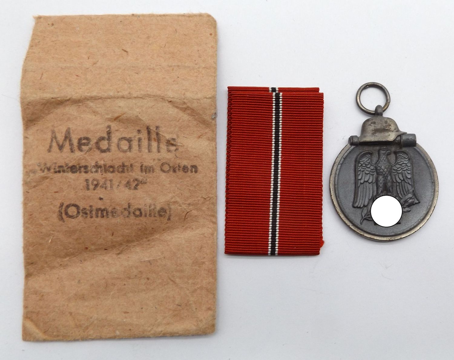 Wehrmacht: Medaille Winterschlacht im Osten, Ostmedaille, Stück mit Hersteller 30, passende Tüte mit Hersteller Hauptmünzamt Wien 40.