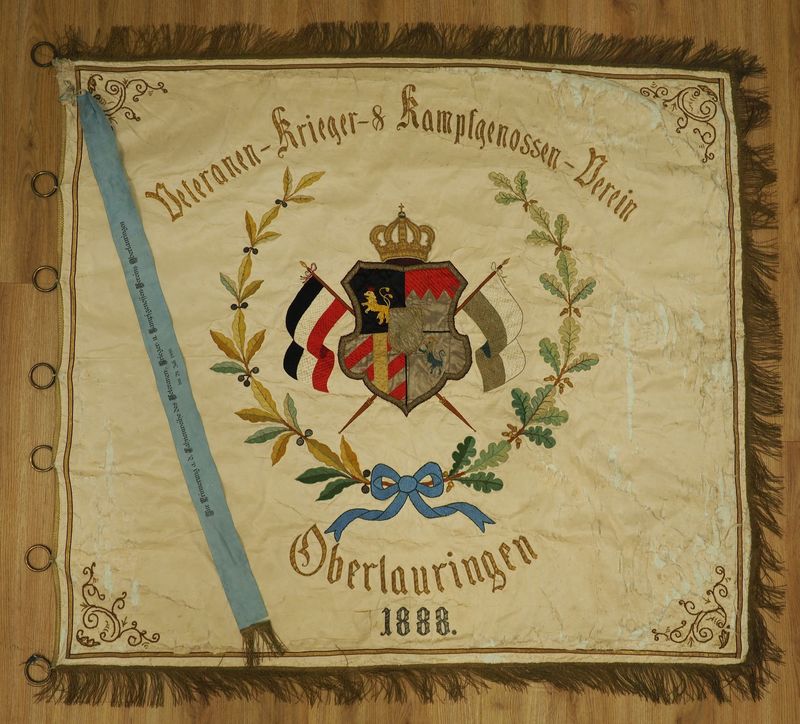 Bayern: Fahne des Veteranen- Krieger- und Kampfgenossen- Vereins Oberlauringen - mit Fahnenband zur Fahnenweihe 1888, beidseitig aufwendig bestickt, Seide beschädigt, Größe ca. 144 x 128 cm.