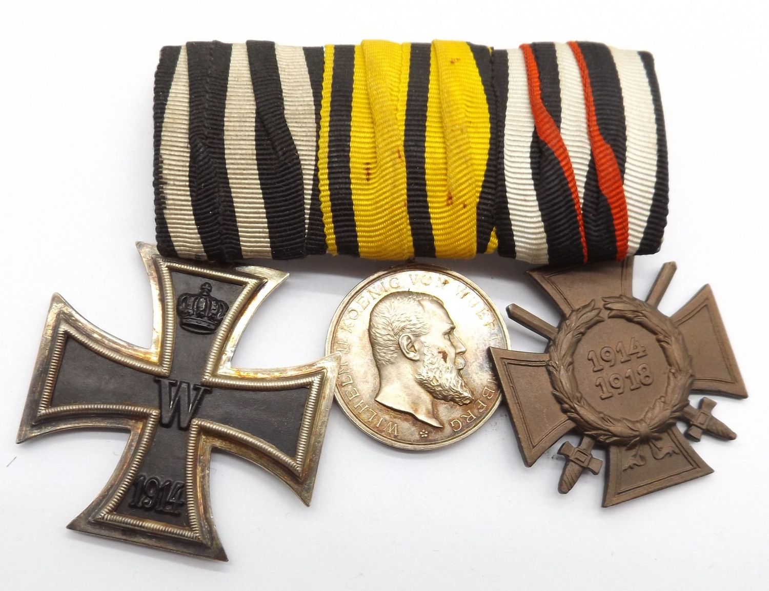 Württemberg: 3-er Ordenschnalle, EK2 (Hersteller We für die Firma J.H. Werner, Berlin), silberne Militärverdienstmedaille, FEK (Hersteller G 4), das Schnallenblech gemarkt D.R.G.M..