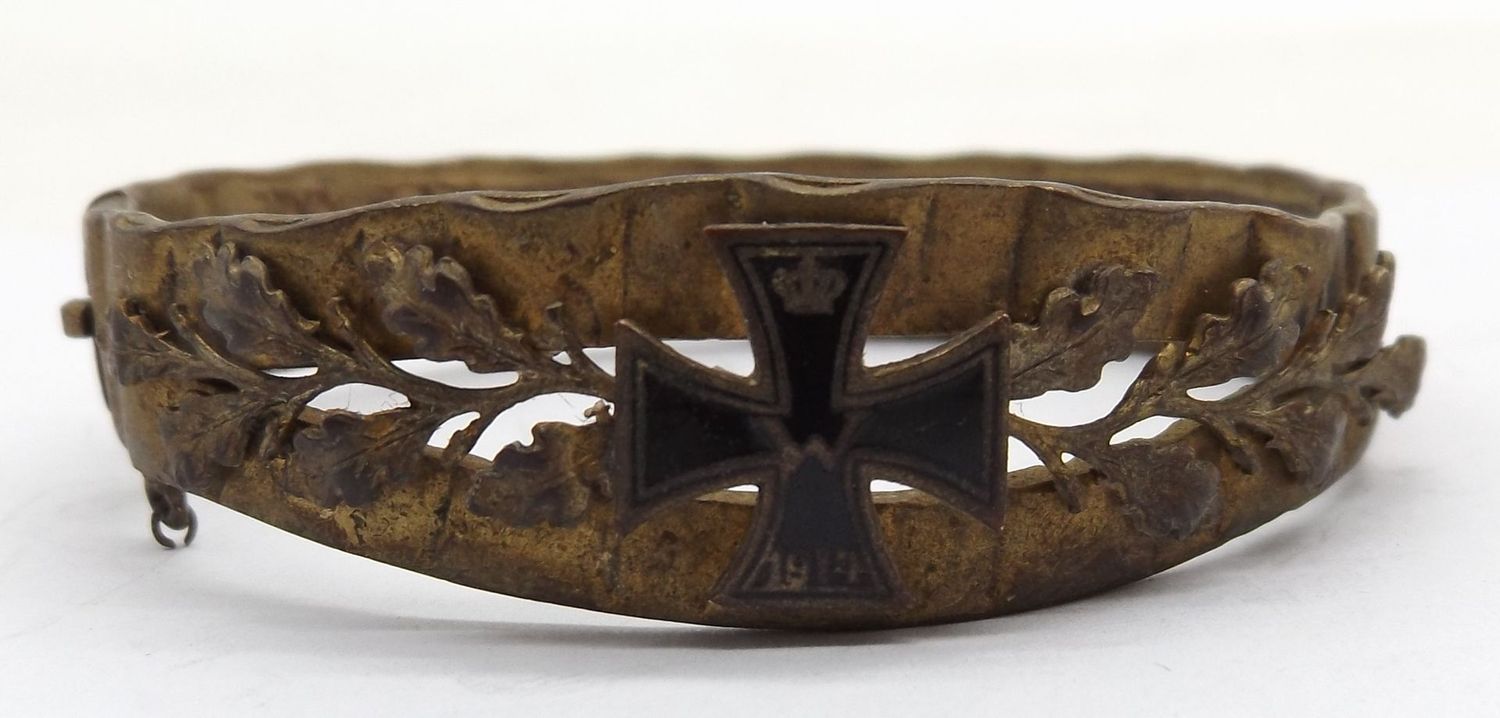 Patriotischer Schmuck-Armreif, 1. Weltkrieg, aus Granatführungsring, aufgelegtes Eisernes Kreuz 1914, Kettchen fehlt, Maße ca. 5,6 x 6 cm.