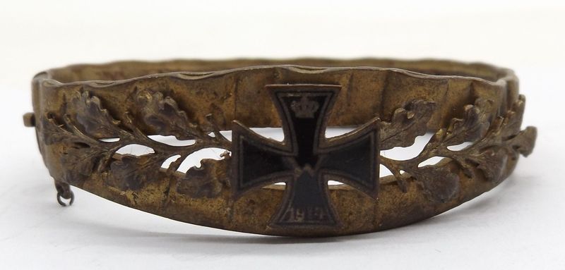 Patriotischer Schmuck-Armreif, 1. Weltkrieg, aus Granatführungsring, aufgelegtes Eisernes Kreuz 1914, Kettchen fehlt, Maße ca. 5,6 x 6 cm.