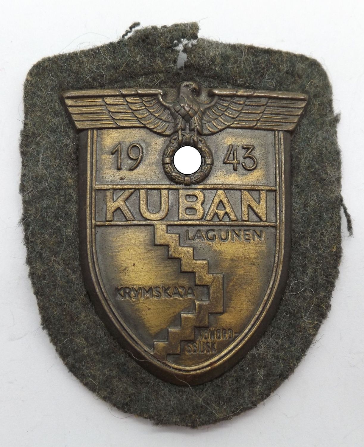 Wehrmacht: Kubanschild 1943, Eisen bronziert, auf Heeresstoff, mit Gegenplatte.