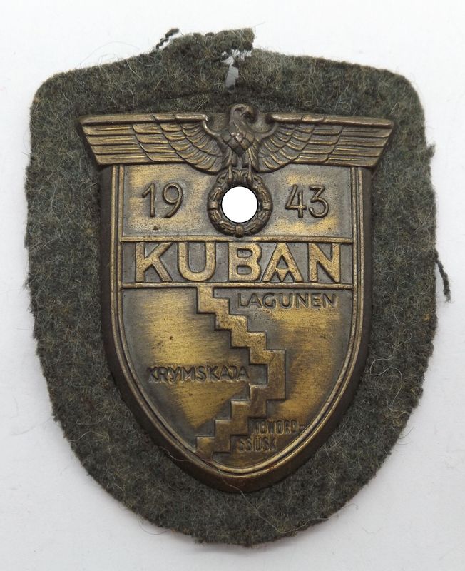 Wehrmacht: Kubanschild 1943, Eisen bronziert, auf Heeresstoff, mit Gegenplatte. Wehrmacht: Kubanschild 1943, Eisen bronziert, auf Heeresstoff, mit Gegenplatte.