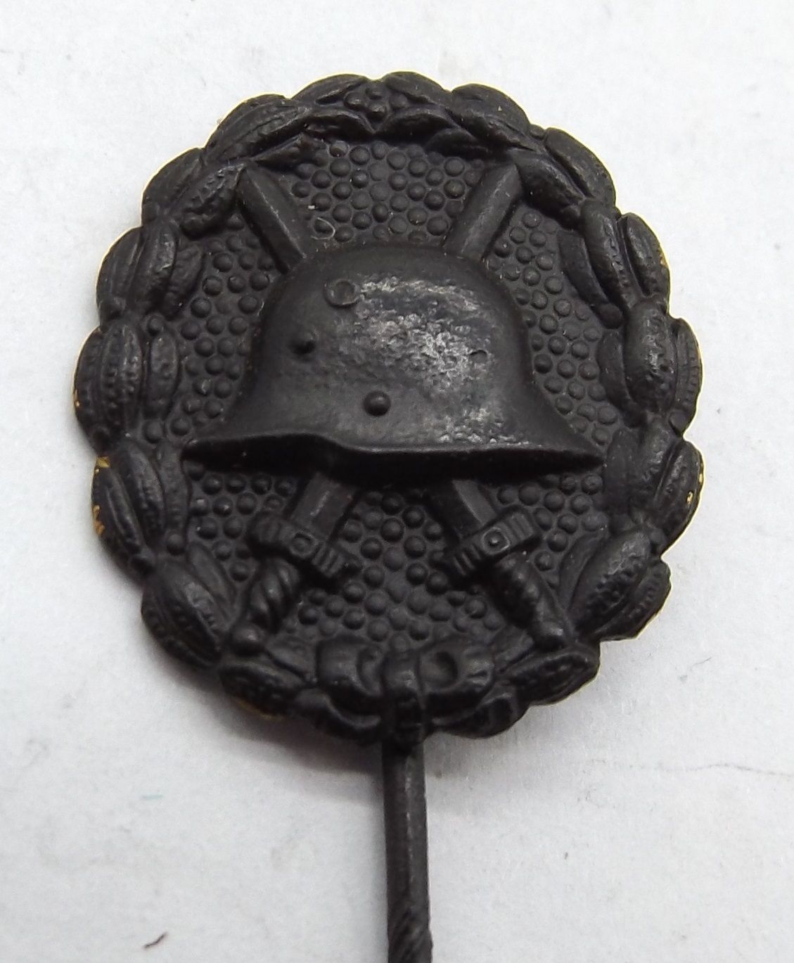 Verwundetenabzeichen in Schwarz 1914, Miniatur, an Nadel, hohl geprägt, Maße ca. 19 x 17 mm.