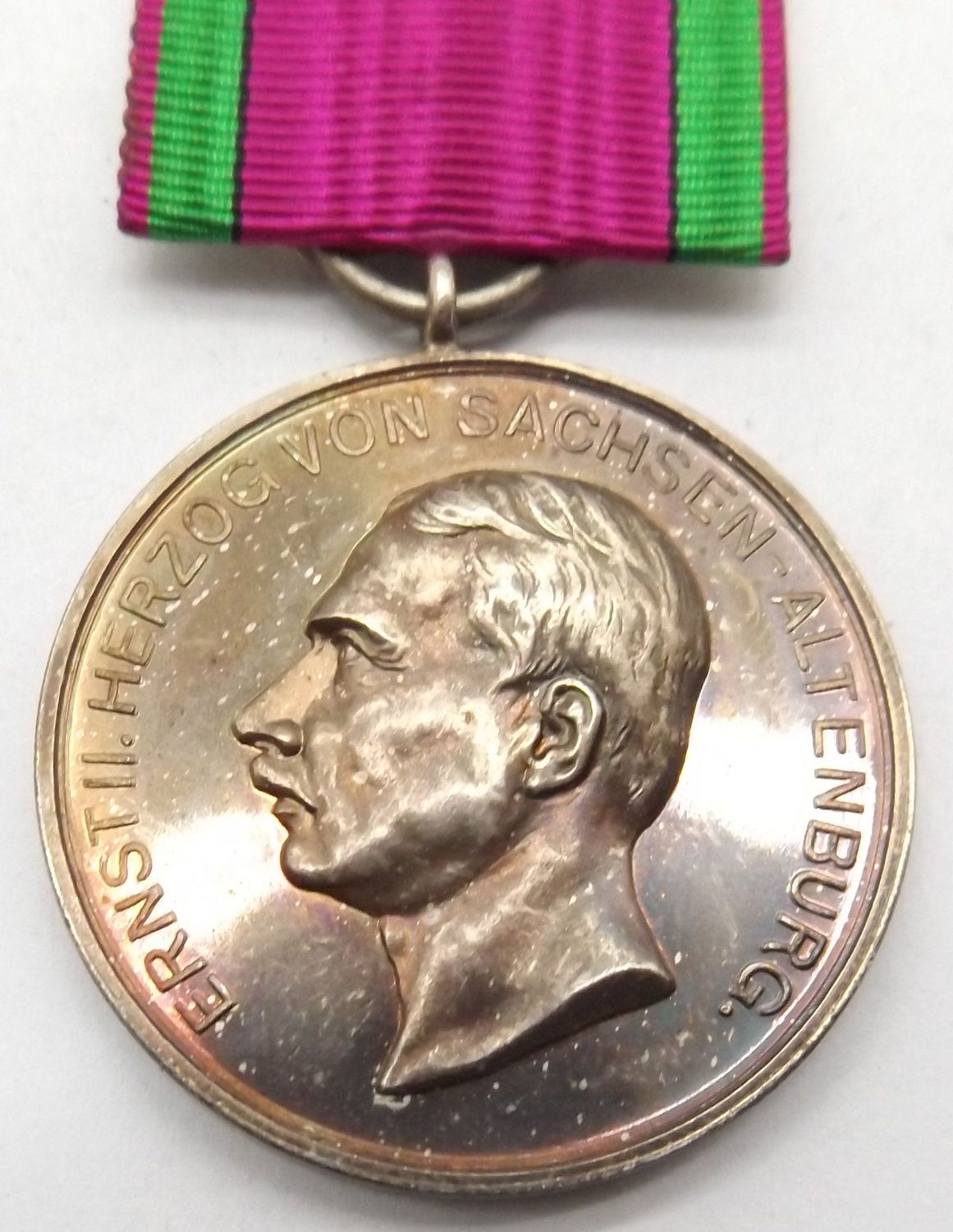 Sachsen-Altenburg: Silberne Verdienstmedaille des Ernestinischen Hausordens (Ernst II.), Silber, am Bande mit rückseitigem alten Sammlungsetikett. Sachsen-Altenburg: Silberne Verdienstmedaille des Ernestinischen Hausordens (Ernst II.), Silber, am Bande mit rückseitigem alten Sammlungsetikett.