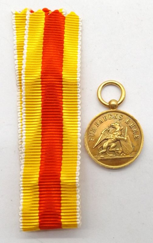Baden: Karl Friedrich Militärverdienstmedaille, in Gold, 16 mm Miniatur. Silber vergoldet, gravierter Name Baden: Karl Friedrich Militärverdienstmedaille, in Gold, 16 mm Miniatur. Silber vergoldet, gravierter Name "LUDWIG", mit Bandstück.