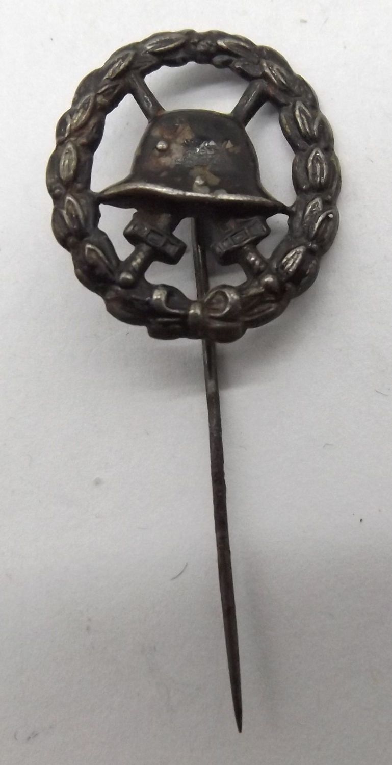 Verwundetenabzeichen in Schwarz 1914, Miniatur, an Nadel, durchbrochene Ausführung, Maße ca. 21 x 18 mm.