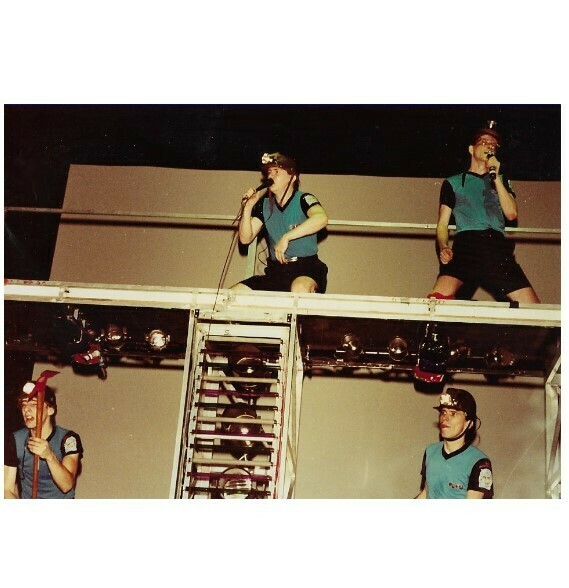 Devo / On Stage, Blue-Black Outfits, Mark On Upper Right | Photo Print | 1981