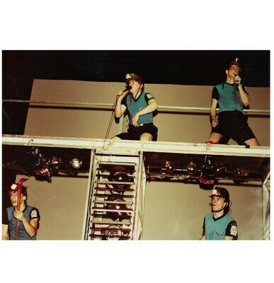 Devo / On Stage, Blue-Black Outfits, Mark On Upper Right | Photo Print | 1981