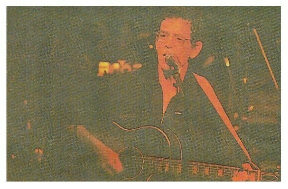 Reed, Lou / On Stage-Orange Lighting-Acoustic Guitar | Magazine Photo | 1992