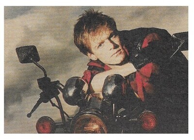 Adams, Bryan / 1984: Wearing Red Jacket - On Motorcycle