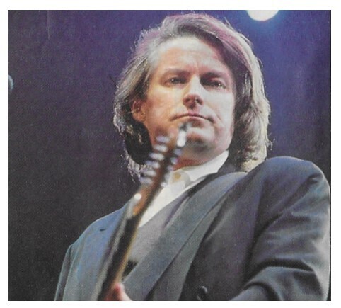 Henley, Don / 1991: On Stage-Navy Blue Jacket-Playing Guitar