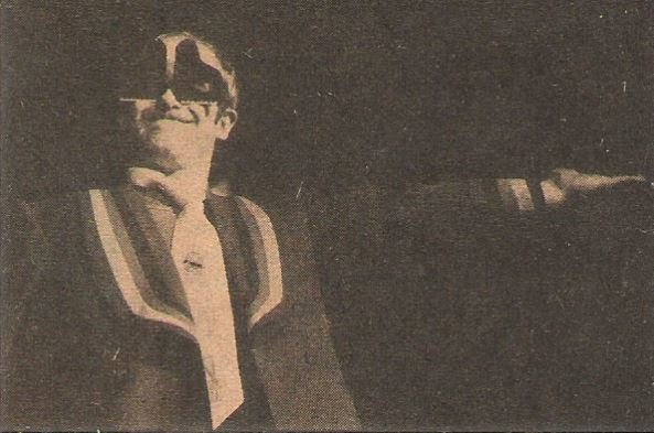 John, Elton / On Stage, Piano Shaped Glasses, Arm Outstretched (1976)