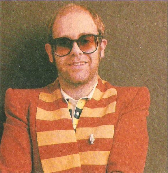 John, Elton / Dark Red Jacket with Tan Stripes, Brown Background | Magazine Photo (1976)