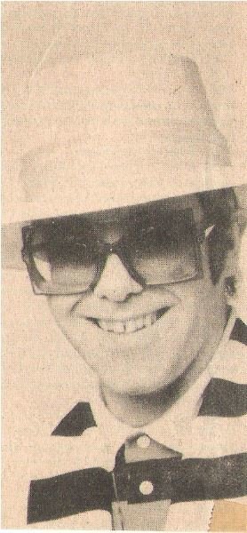 John, Elton / Closeup, Smiling, Light Color Hat, Striped Shirt (1976)