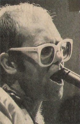 John, Elton / On Stage, Closeup, Profile, Singing Into Microphone | Magazine Photo (1976)