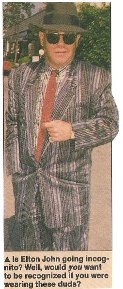 John, Elton / In Striped Suit, Red Tie, Black Hat | Magazine Photo with Caption (1987)