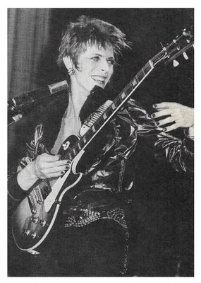 Bowie, David / On Stage, Smiling, with Electric Guitar / 1970s