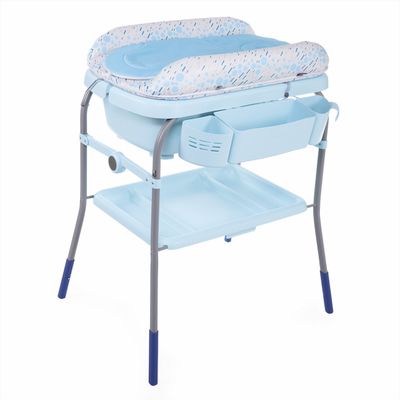 Imagem da Banheira com Trocador Cuddle &amp; Bubble Chicco aberta, mostrando a banheira com água, o bebê brincando dentro dela e os pais ao lado com o trocador aberto e os produtos de higiene organizados.