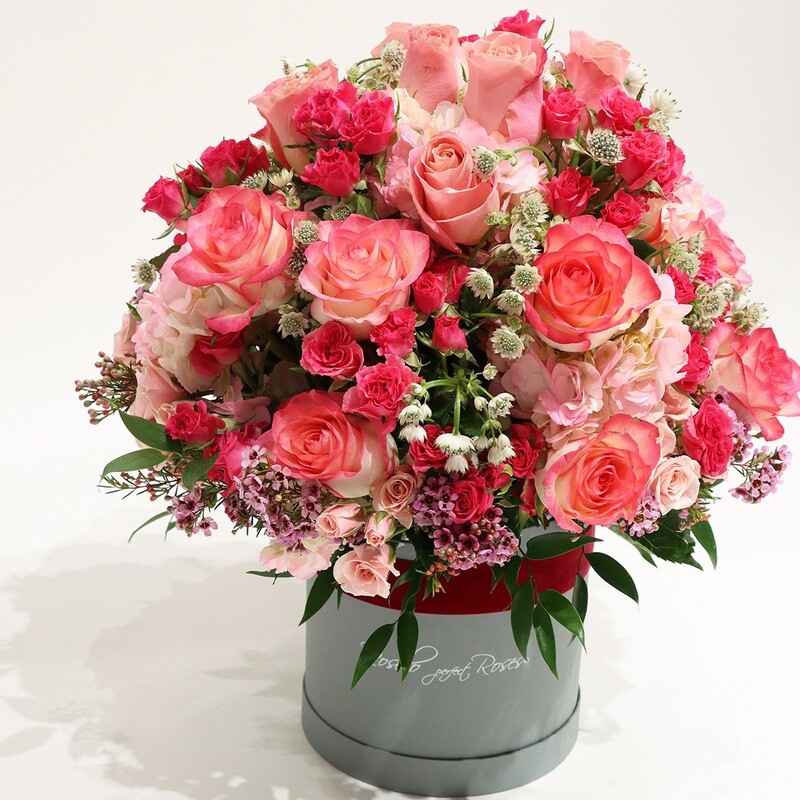 Roses, roses branchues et hortensias dans une belle boîte
