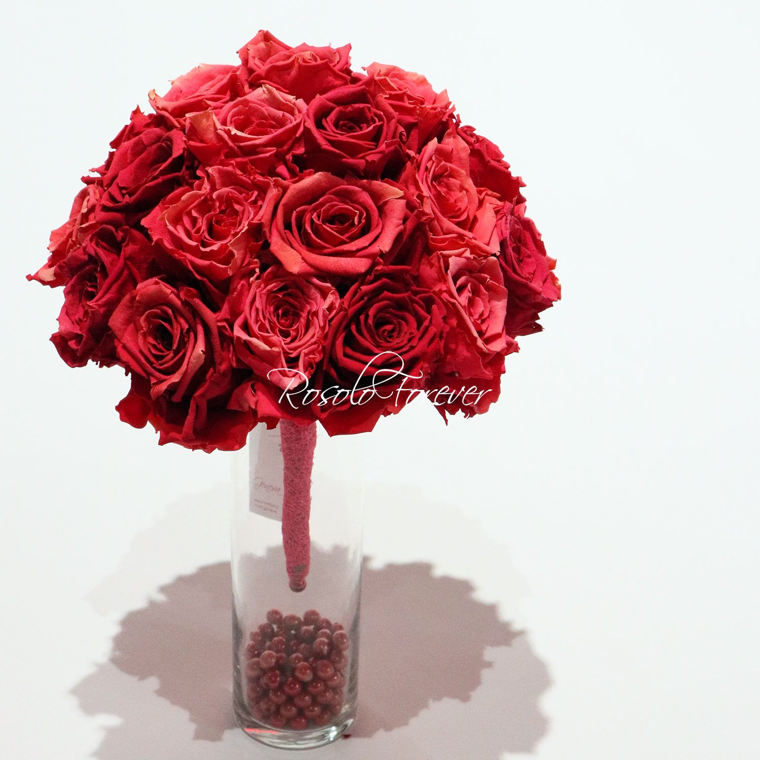 Joli bouquet compact de roses stabilisées, tons de rouge