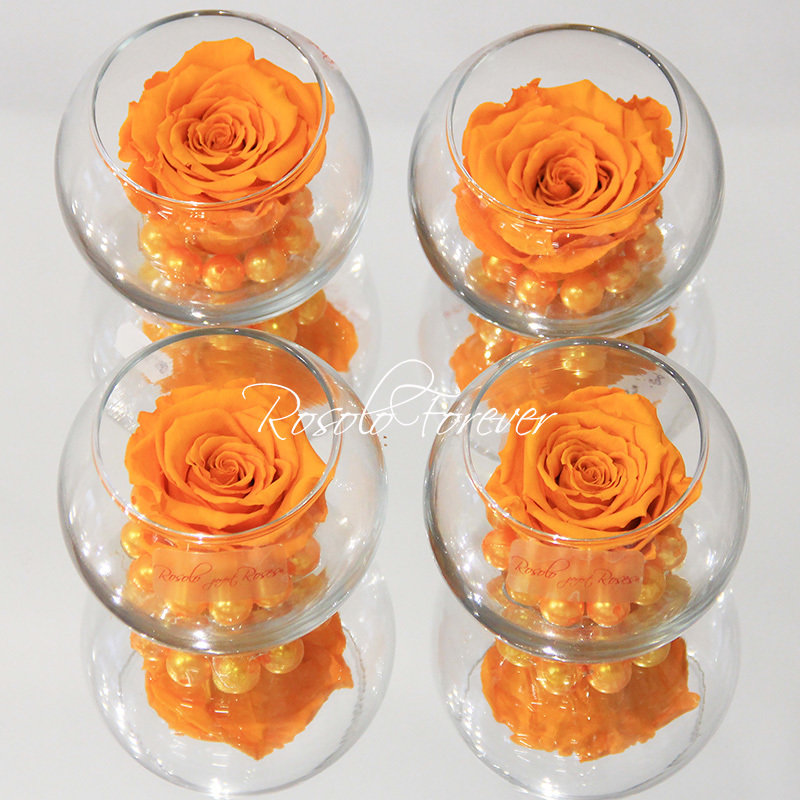 Une rose stabilisée en orange claire, avec perles décoratives dans un verre