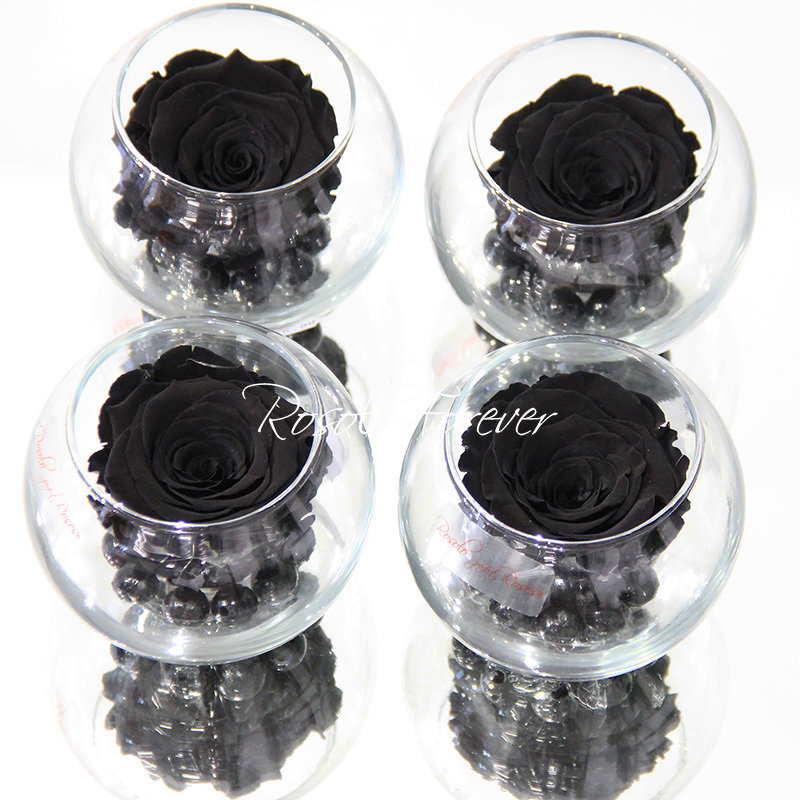 Une rose stabilisée en noir, avec perles décoratives dans un verre