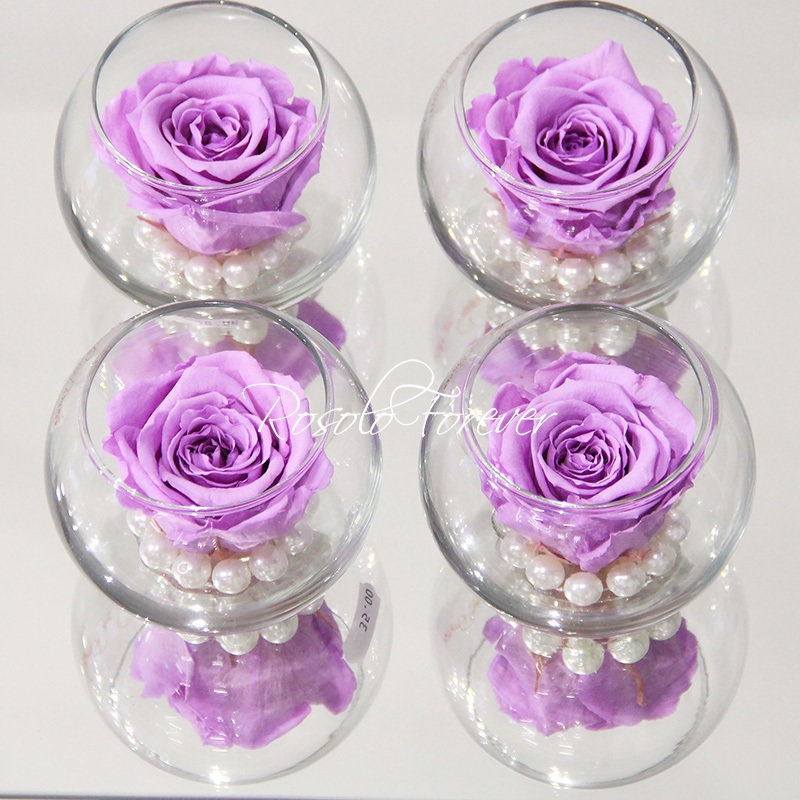 Une rose stabilisée en mauve, avec perles décoratives dans un verre