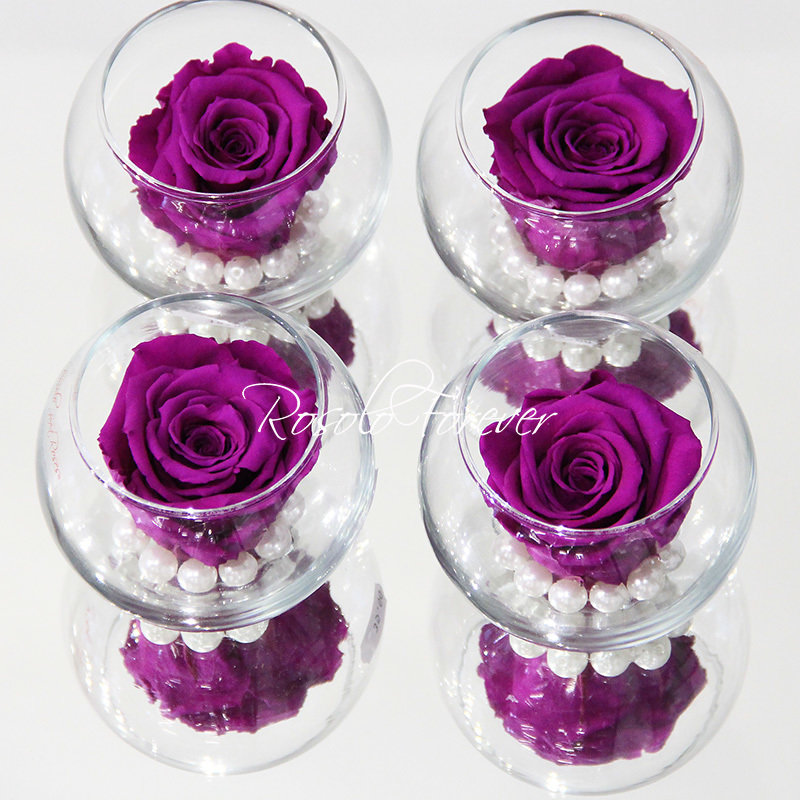 Une rose stabilisée violette, avec perles décoratives dans un verre