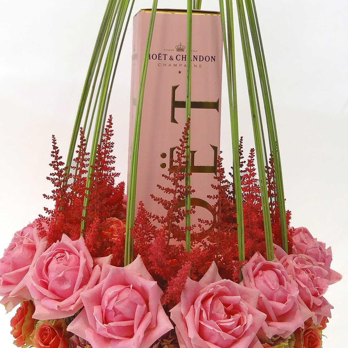 Champagne rosé dans une composition de roses