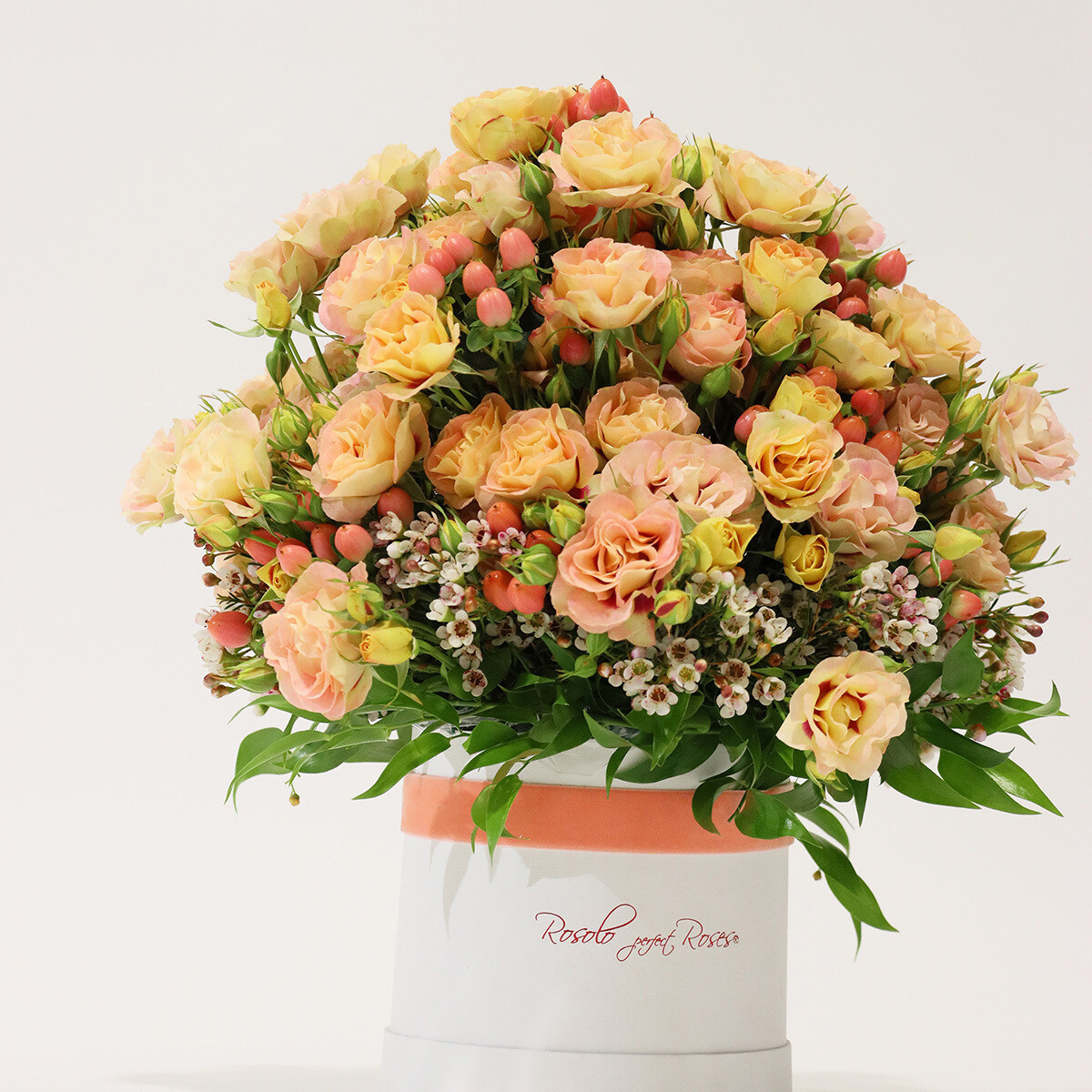 Boite Rosolo avec belles roses, couleur saumon, baies et garniture de saison