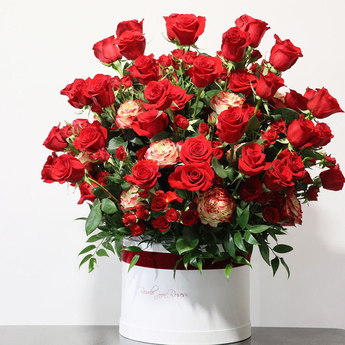 Principalement rouge, bel effet, grandes roses dans une superbe boîte