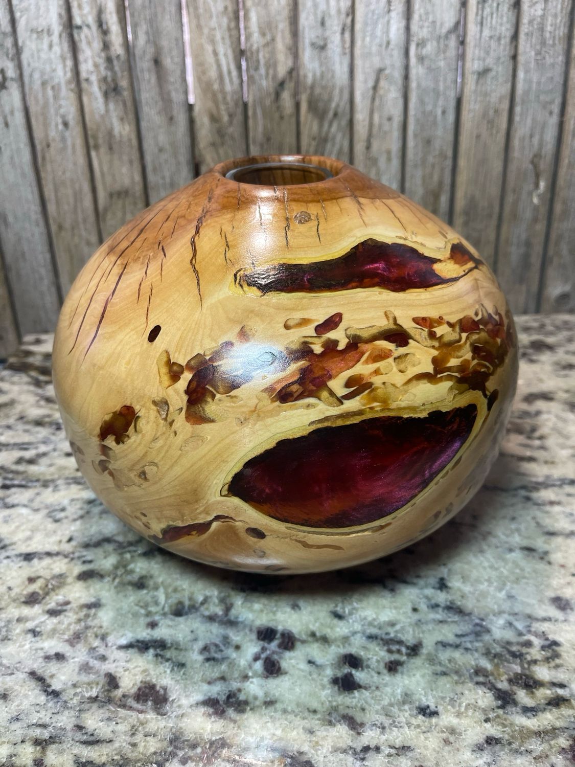 Handcrafted apple burl globe vase with natural wood grains
Shown under artificial light

