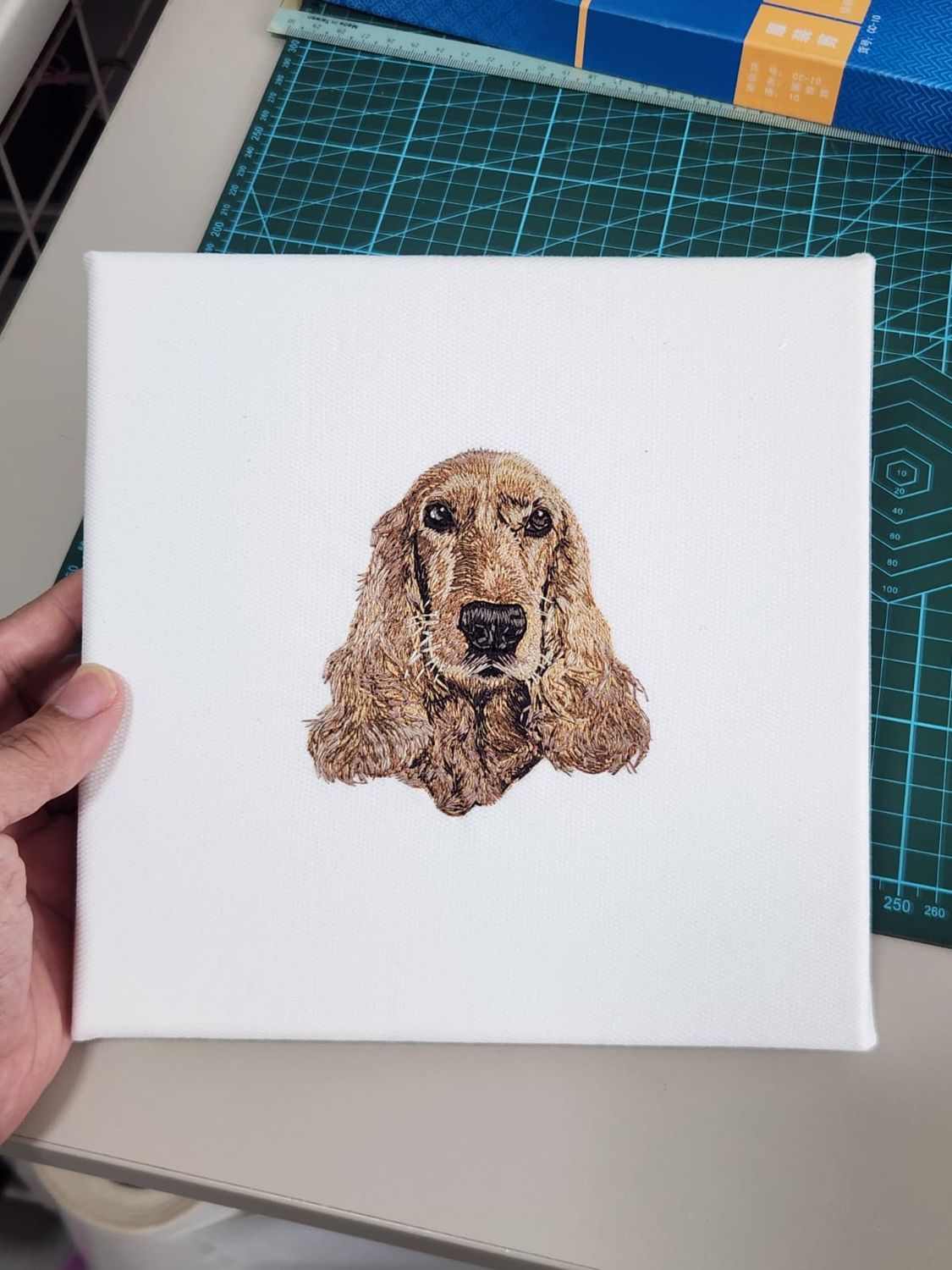 Custom machine-embroidered pet portrait on a framed canvas, showing detailed stitching and realistic shading.