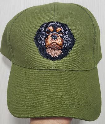 Olive green baseball cap featuring a detailed custom embroidered head of a black and tan Cavalier King Charles Spaniel dog.
