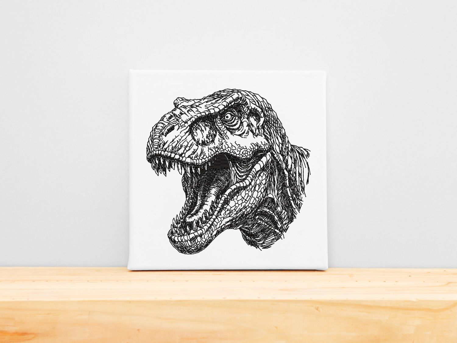 High-precision black machine embroidery of a Tyrannosaurus Rex head with an open roar on a white stretched canvas frame.